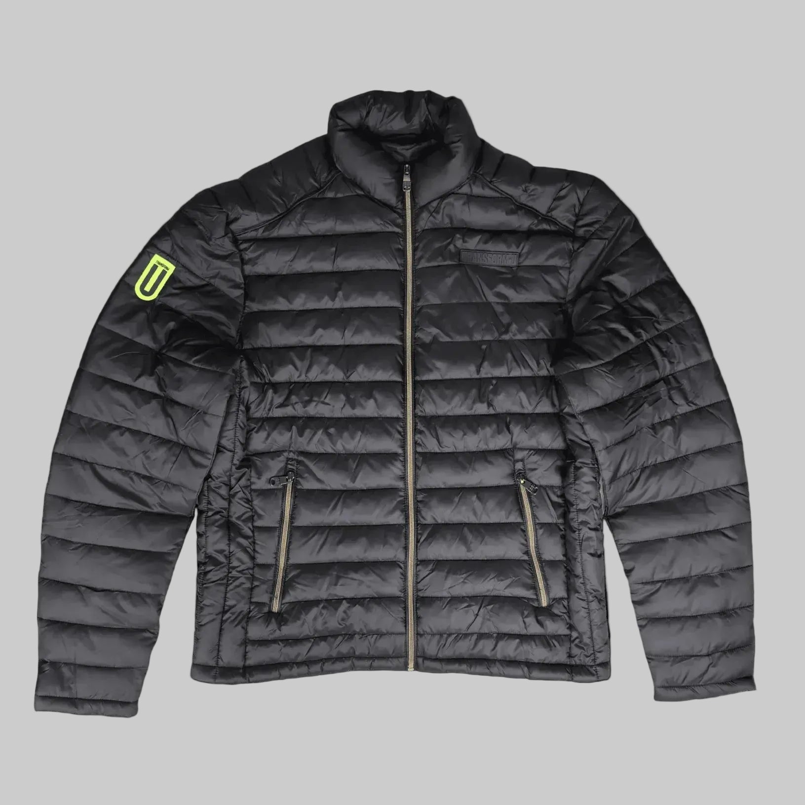 A dark gray quilted puffer jacket with a high collar, front zipper, and two zippered hand pockets. A bright neon yellow-green shield logo is visible on the left sleeve.