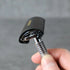 Hand holding a safety razor with protective cover on against a gray background