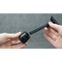 Two hands holding a black safety razor against a gray background