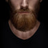 Close-up of a man with a full beard against a black background