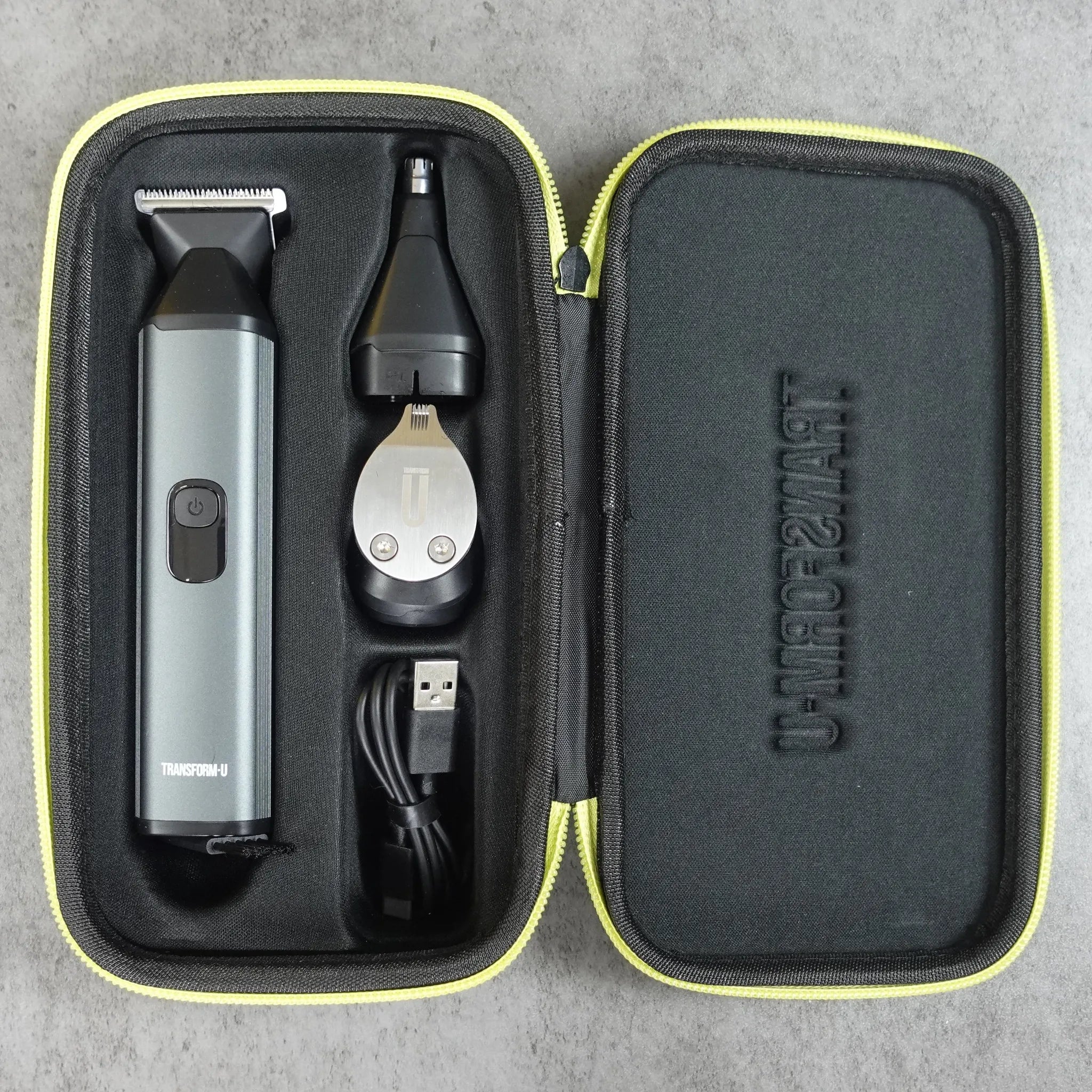 Hair trimming kitwith trimmer, ear cleaner, and USB cable in a black carrying case on a gray background.
