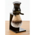 Shaving brush with black stand on a wooden surface