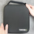 a black travel case for a hair clipper on dark background