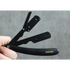 Black straight razor with 'Transform-U' branding held by a hand against a gray background