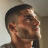 Man with a styled haircut and beard looking upwards