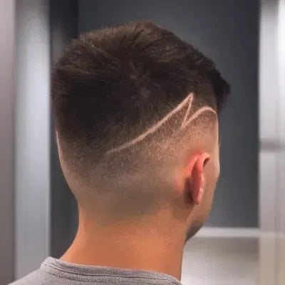 Man with a stylish haircut featuring a line design on the back of his head.
