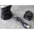 Black electrical travel shaver with charging cable and adapter on a gray surface