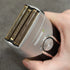 Hand holding a electric shaver with gold foil and 'Transform-U' branding.