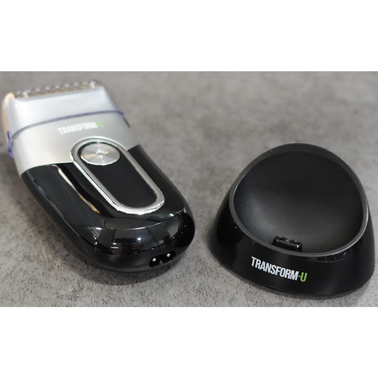 Electric shaver and charging stand on a gray surface